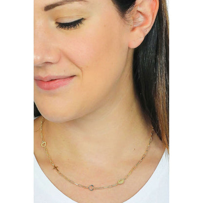 Detail van de goudkleurige Amen ketting met elegante hangers, gedragen door een vrouw.