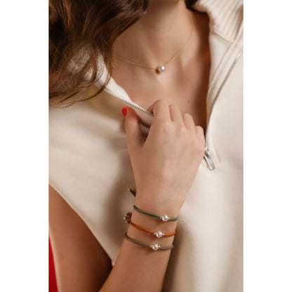 Detail van de Majorica armband met parel, gecombineerd met kleurrijke koorden.