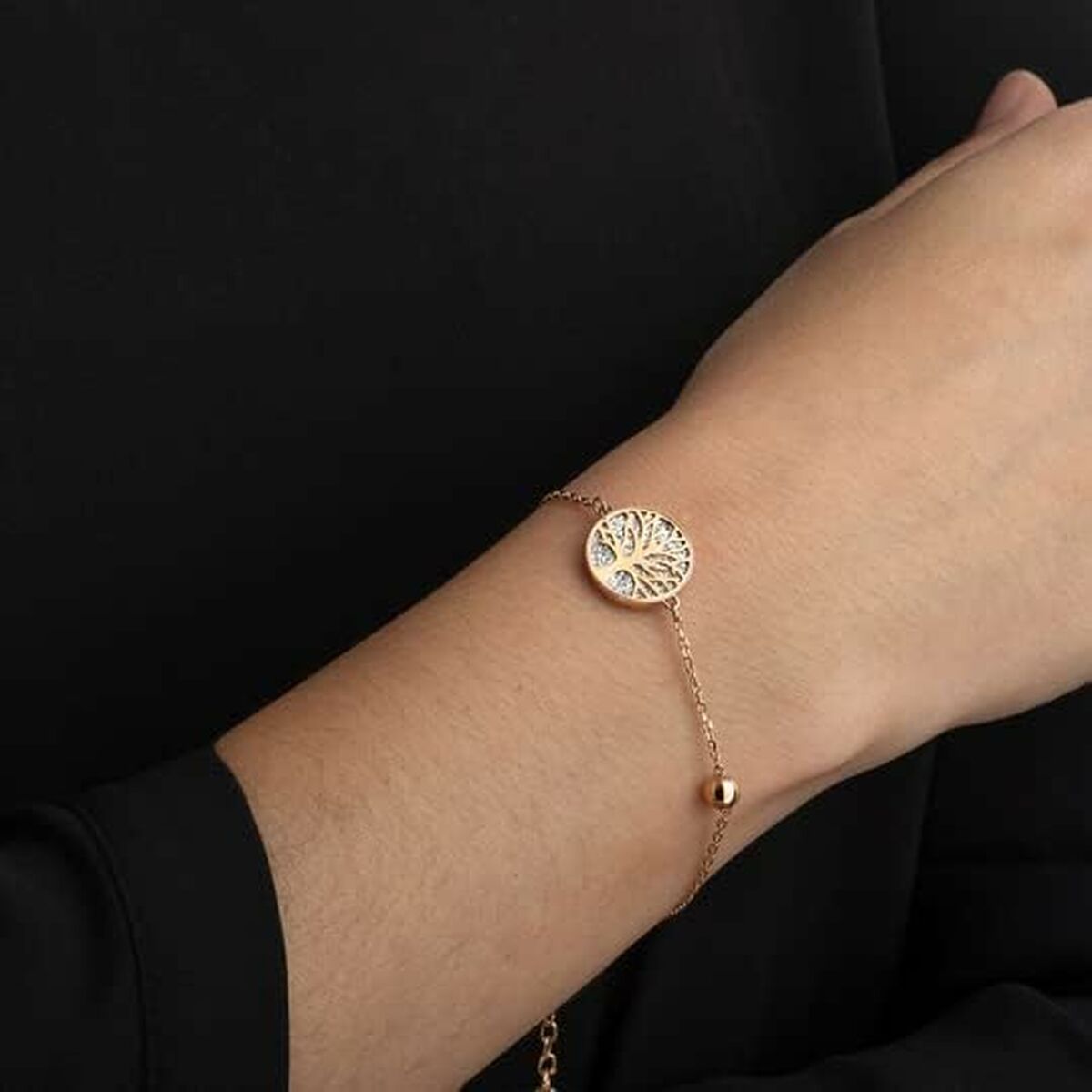 Detail van de Lotus armband met een ronde schijf en boomdesign, elegant gedragen om de pols.