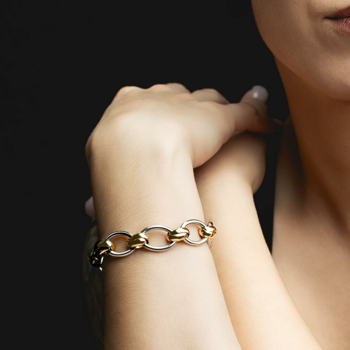 Detail van de gouden Lotus armband met schakels, elegant gedragen om de pols.
