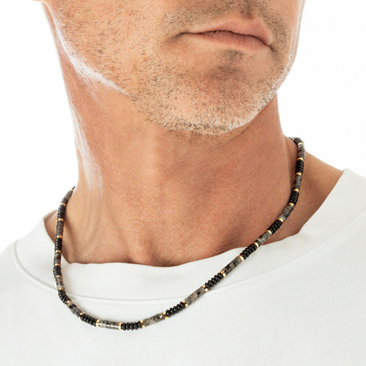 Detail van de Lotus ketting met elegante kralen in zwart en grijs, gedragen door een man.