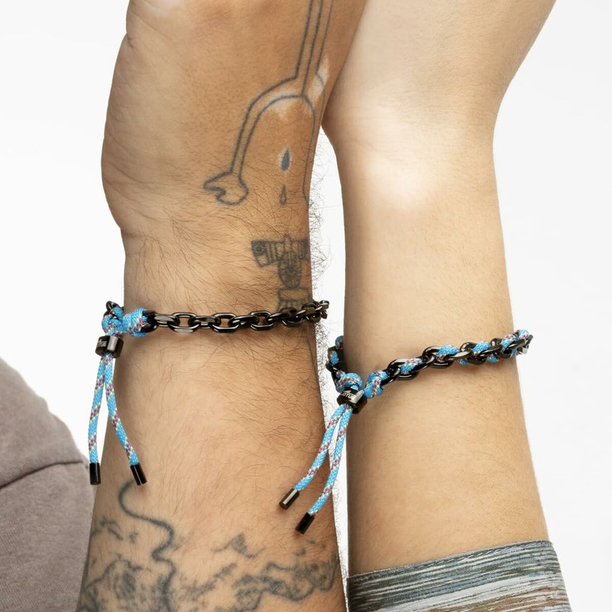 Detail van de Lotus armband met zwart en blauw koord, gedragen om de pols.