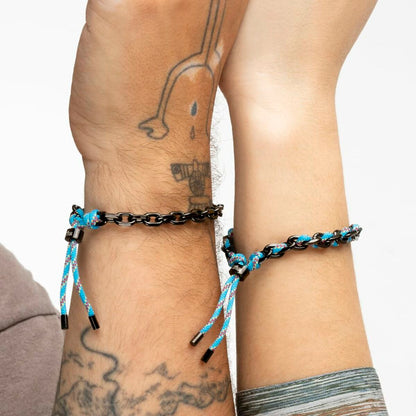 Detail van de Lotus armband met zwart en blauw koord, gedragen om de pols.