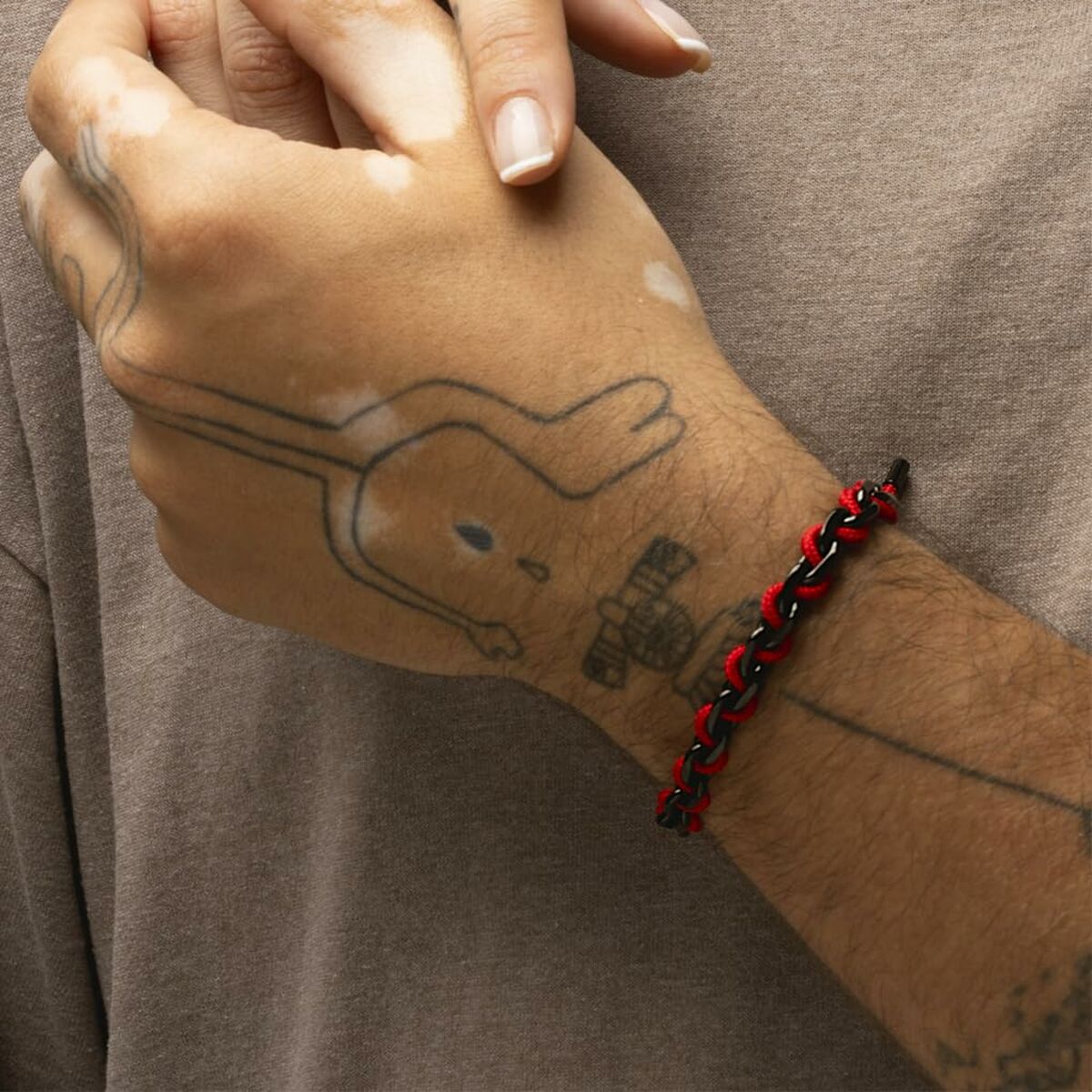 Detail van de Lotus armband LS2376-2/6 in zwart en rood, gedragen om een pols.