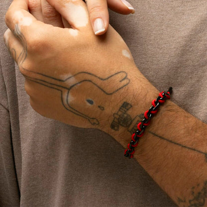Detail van de Lotus armband LS2376-2/6 in zwart en rood, gedragen om een pols.