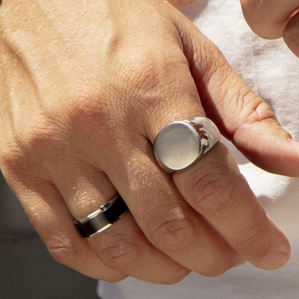 Zilverkleurige Lotus ring op een hand, met een gladde, elegante afwerking.