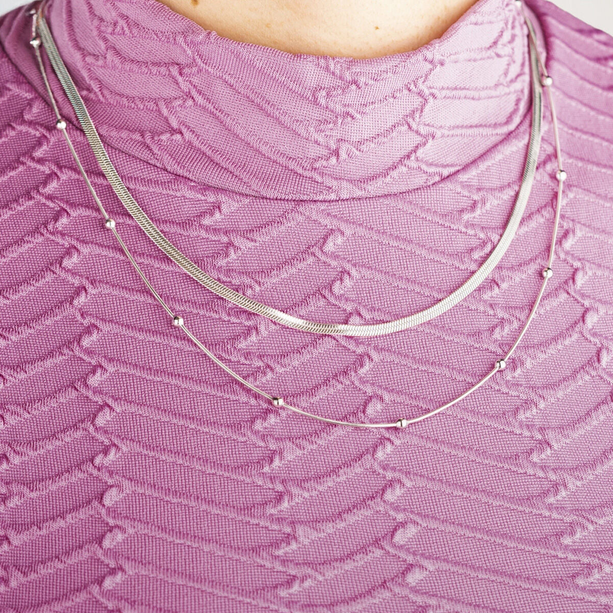 Detail van de zilverkleurige Lotus ketting met elegante schakel en kleine kralen.