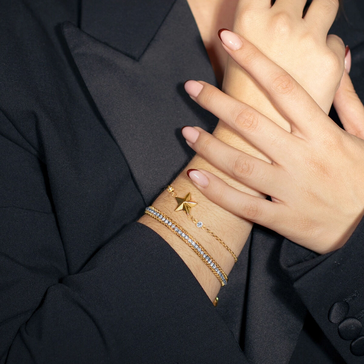 Detail van de gouden Lotus armband met sterren en sprankelende elementen om de pols.