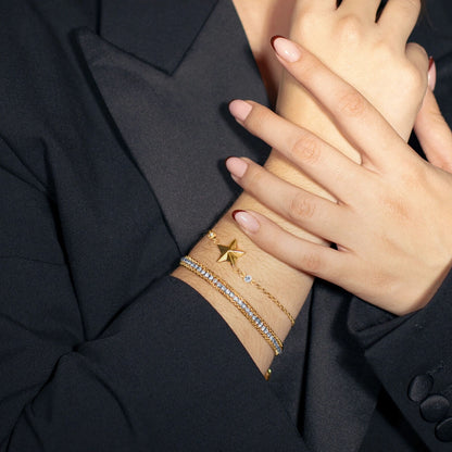 Detail van de gouden Lotus armband met sterren en sprankelende elementen om de pols.