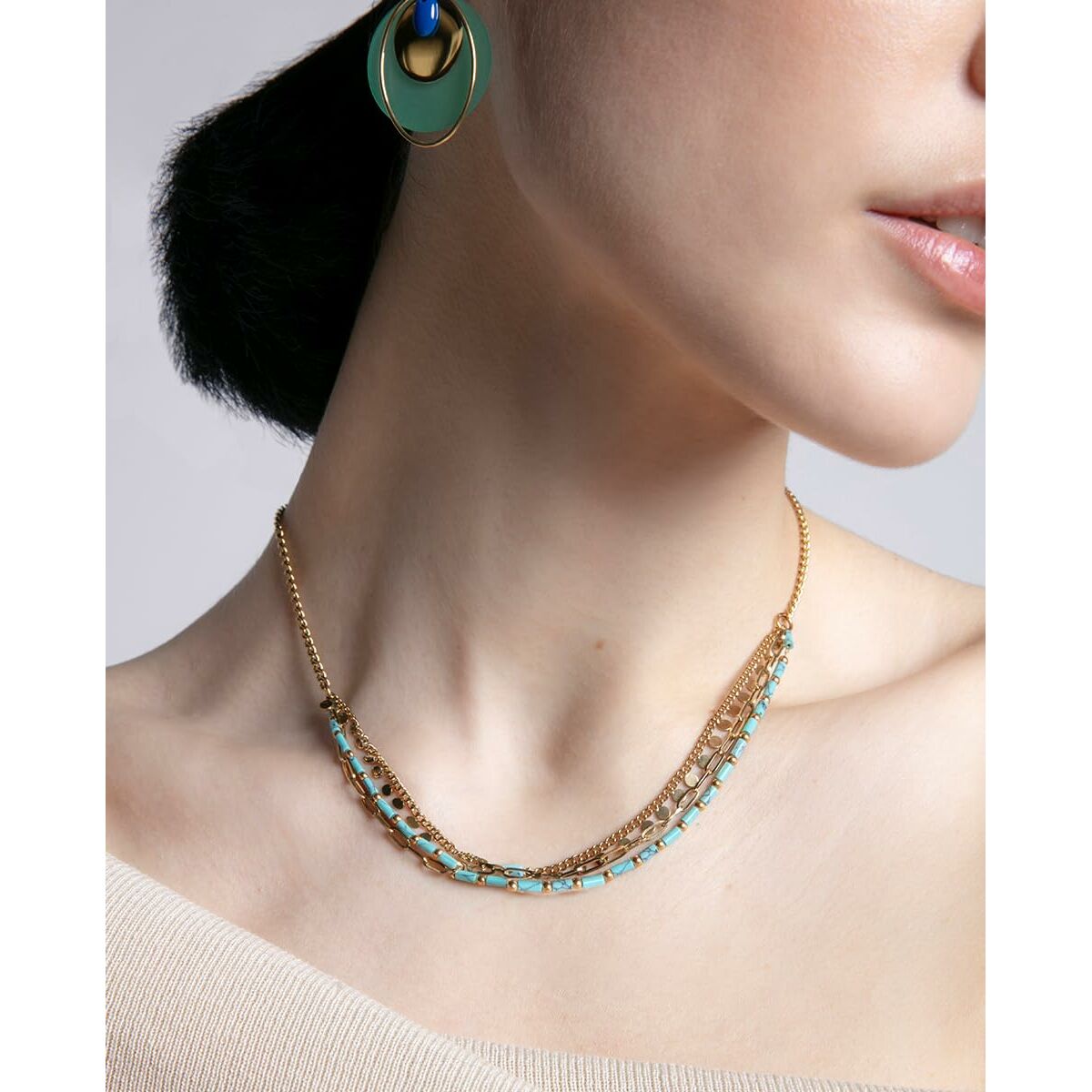 Detail van Viceroy oorbel met elegante gouden kleur, gedragen door model met halsketting.
