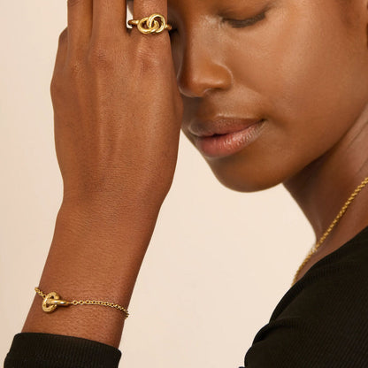 Detail van de gouden Radiant armband met een elegant knoopontwerp om de pols.