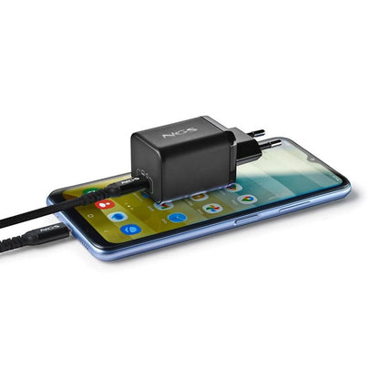 Zwarte NGS powerbank aangesloten op een smartphone met oplaadkabel.