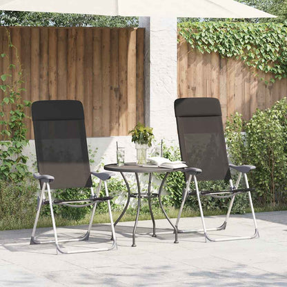 Set van twee zwarte inklapbare campingstoelen van vidaXL, geplaatst naast een tafel in de tuin.