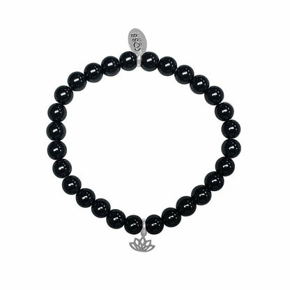 Detail van de zwarte CO88 Collection armband met elegante lotusbedel.