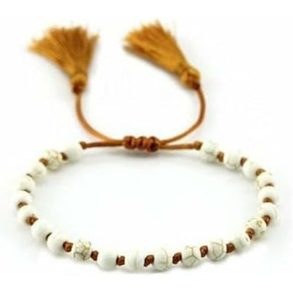 Detail van de witte CO88 Collection armband met franjes en decoratieve kralen.