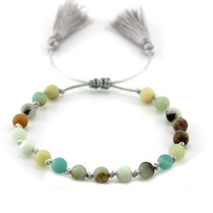 Groene CO88 Collection armband met elegante kralen en kwastjes aan de uiteinden.