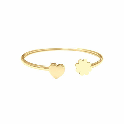 Detail van de gouden CO88 Collection armband met hart- en bloemvormige elementen.