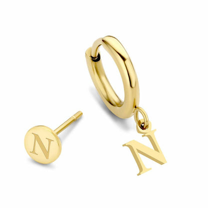 Close-up van de gouden CO88 Collection oorbellen met een hangend letter N-symbool.