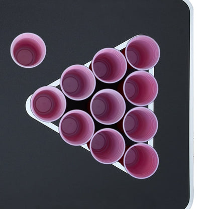 Detail van de bierpongtafel met roze bekers in een driehoekige opstelling.