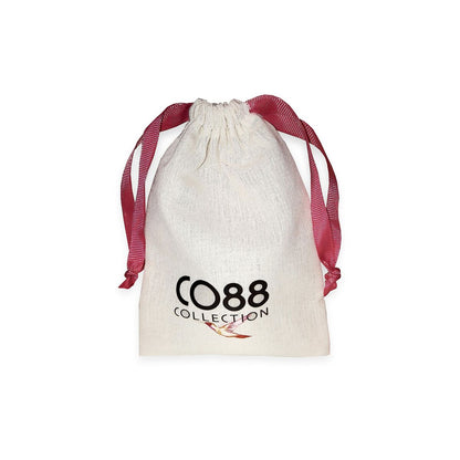 Witte sieradentas van CO88 Collection met rode strik en logo.