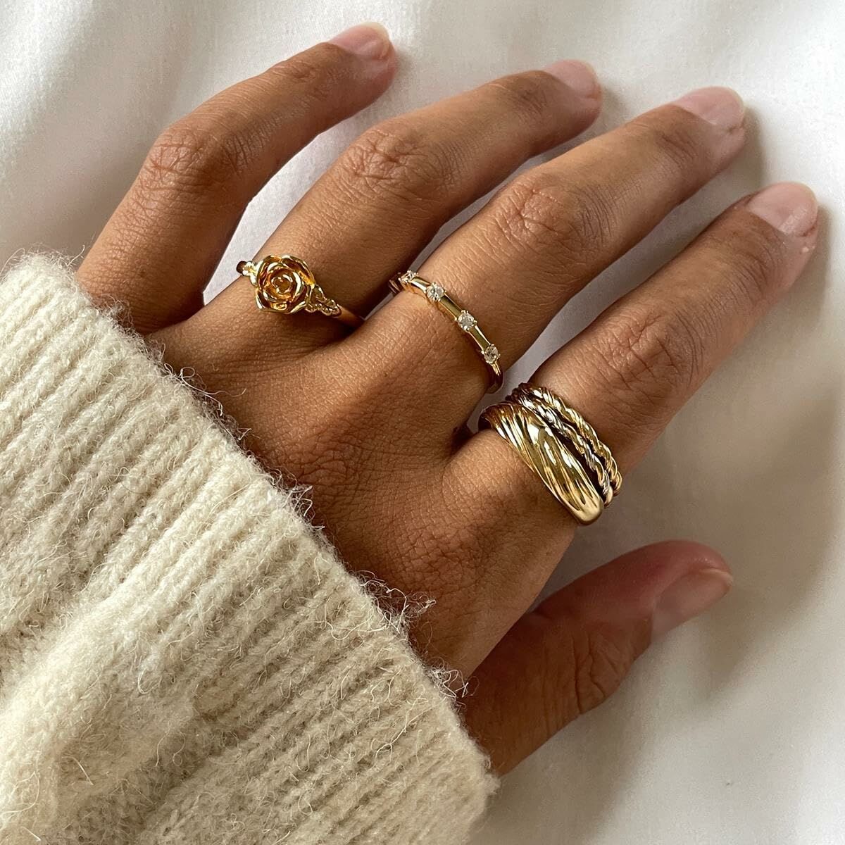 Detail van de 24KAE gouden ring, gedragen samen met andere stijlvolle ringen.