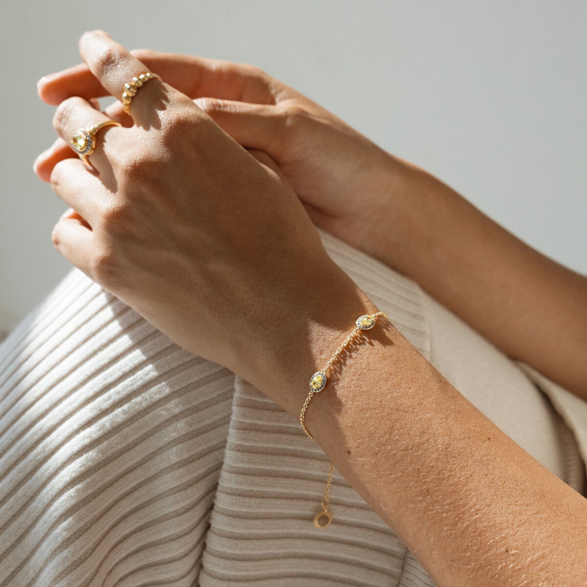 Detail van de 24KAE gouden armband met verfijnde afwerking, gedragen om een pols.
