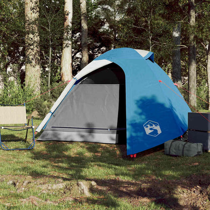 Zijaanzicht van de vidaXL koepeltent in blauw, met open ingang en campingstoel ernaast.