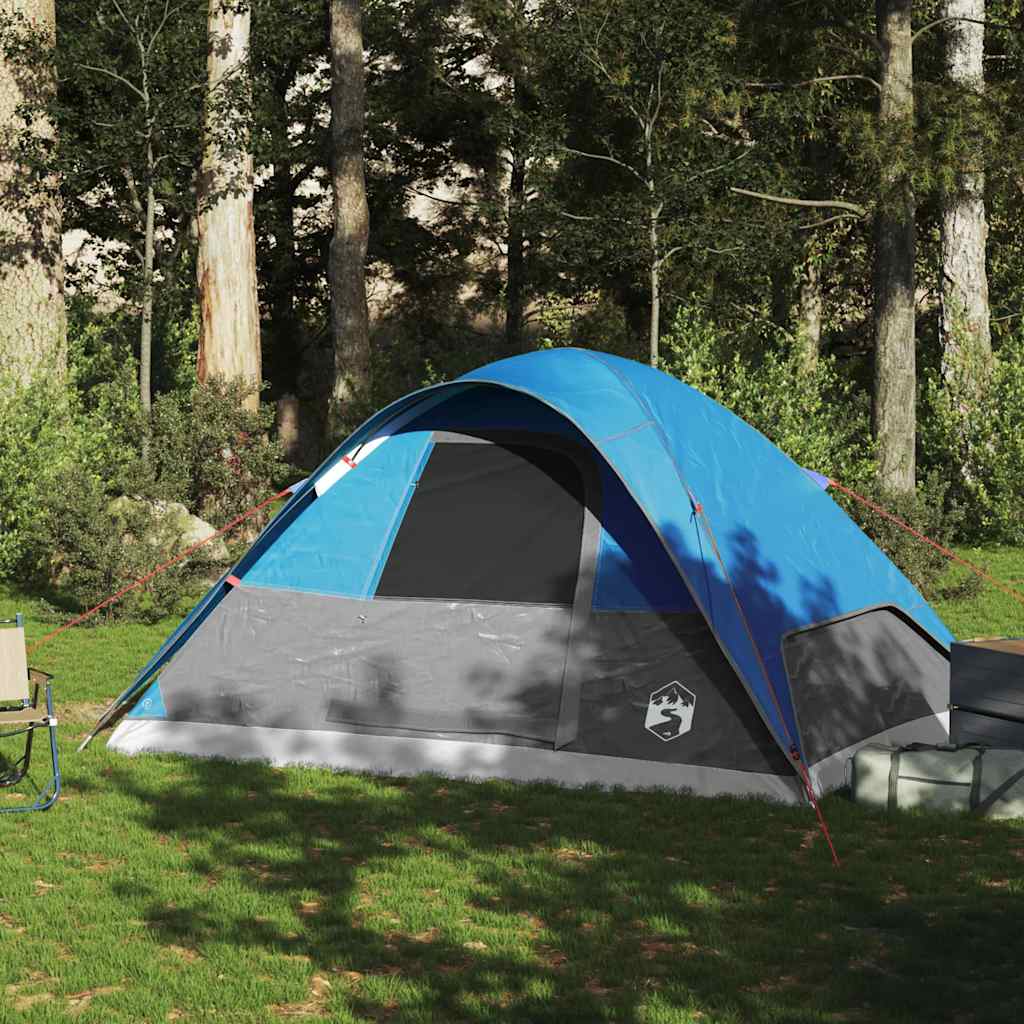Zijaanzicht van de vidaXL koepeltent in blauw, geplaatst op gras met bomen op de achtergrond.