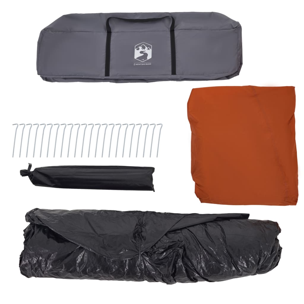 Detail van de grijze tent met oranje luifel en opbergzakken, inclusief haringen en stokken.