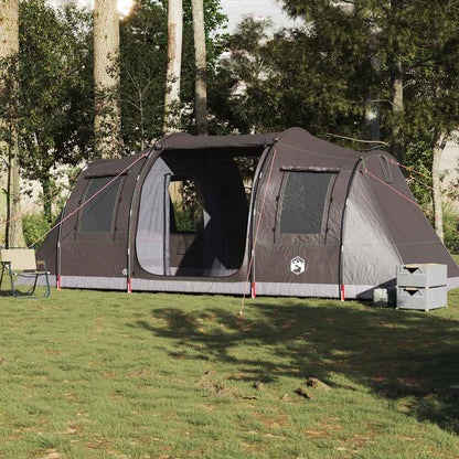 Zijaanzicht van de vidaXL 4-persoons tunneltent in bruin, opgesteld op een groene campinglocatie.