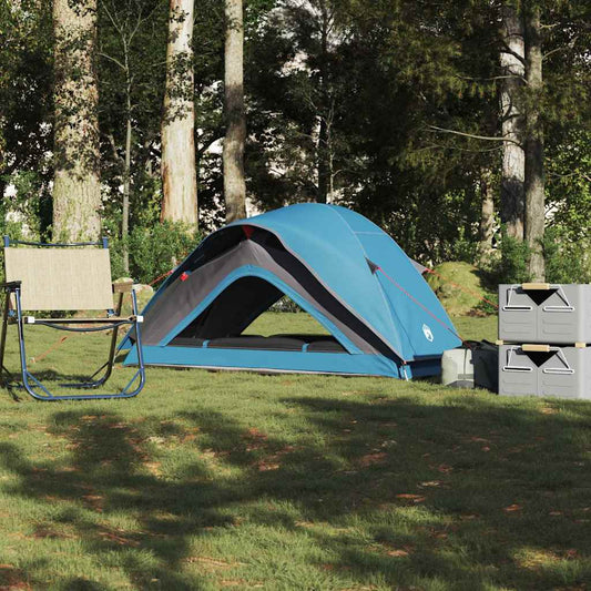 Blauwe vidaXL 1-persoons tent, waterdicht, opgesteld op gras met campingstoelen en kisten.