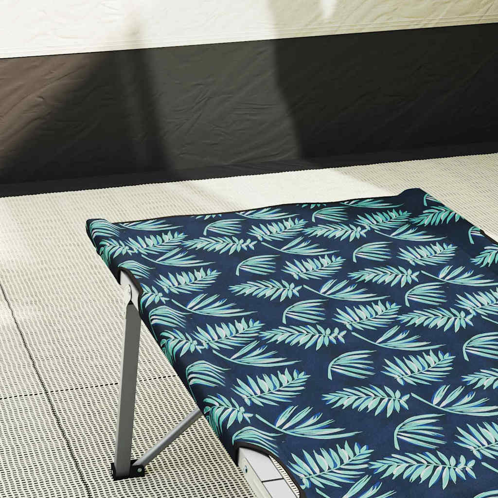 Detail van het opvouwbare camping bed met bladerenpatroon in groen en blauw.