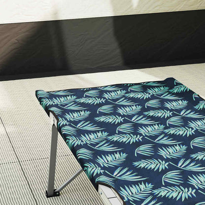 Detail van het opvouwbare camping bed met bladerenpatroon in groen en blauw.