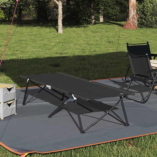 Opvouwbaar vidaXL campingbed in zwart, geplaatst op gras met campingstoelen.