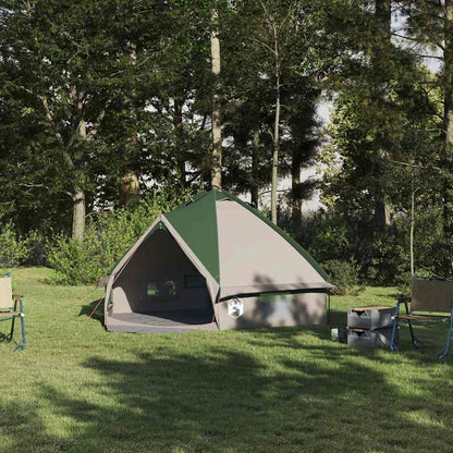 vidaXL Teepee Tent voor 4 Personen in groen, geplaatst op gras met campingstoelen eromheen.