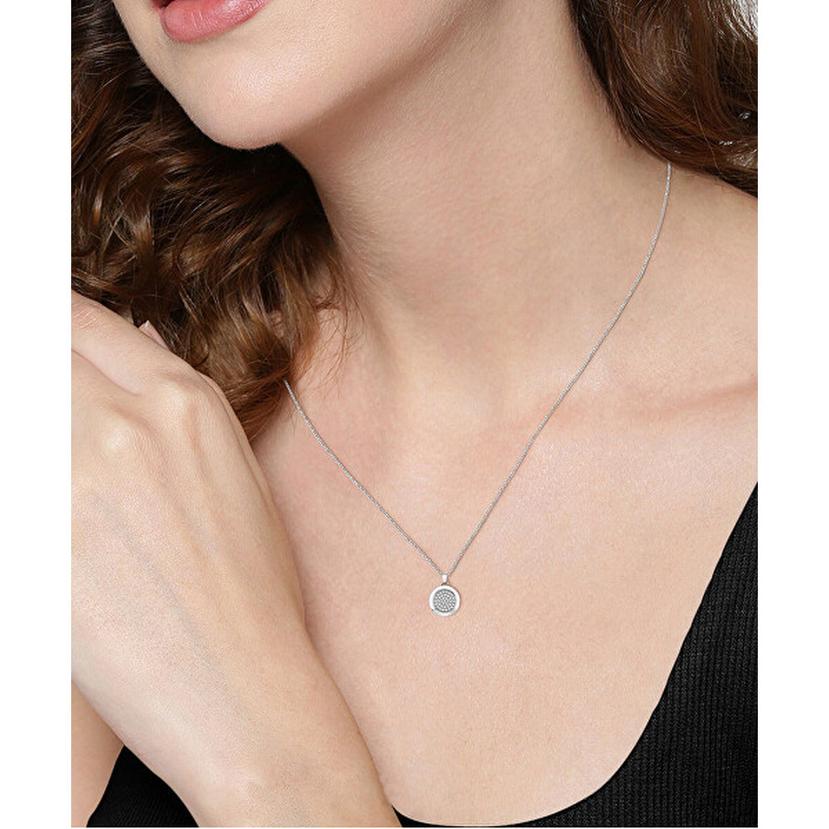 Zilverkleurige Hugo Boss ketting met ronde hanger, gedragen door een vrouw.