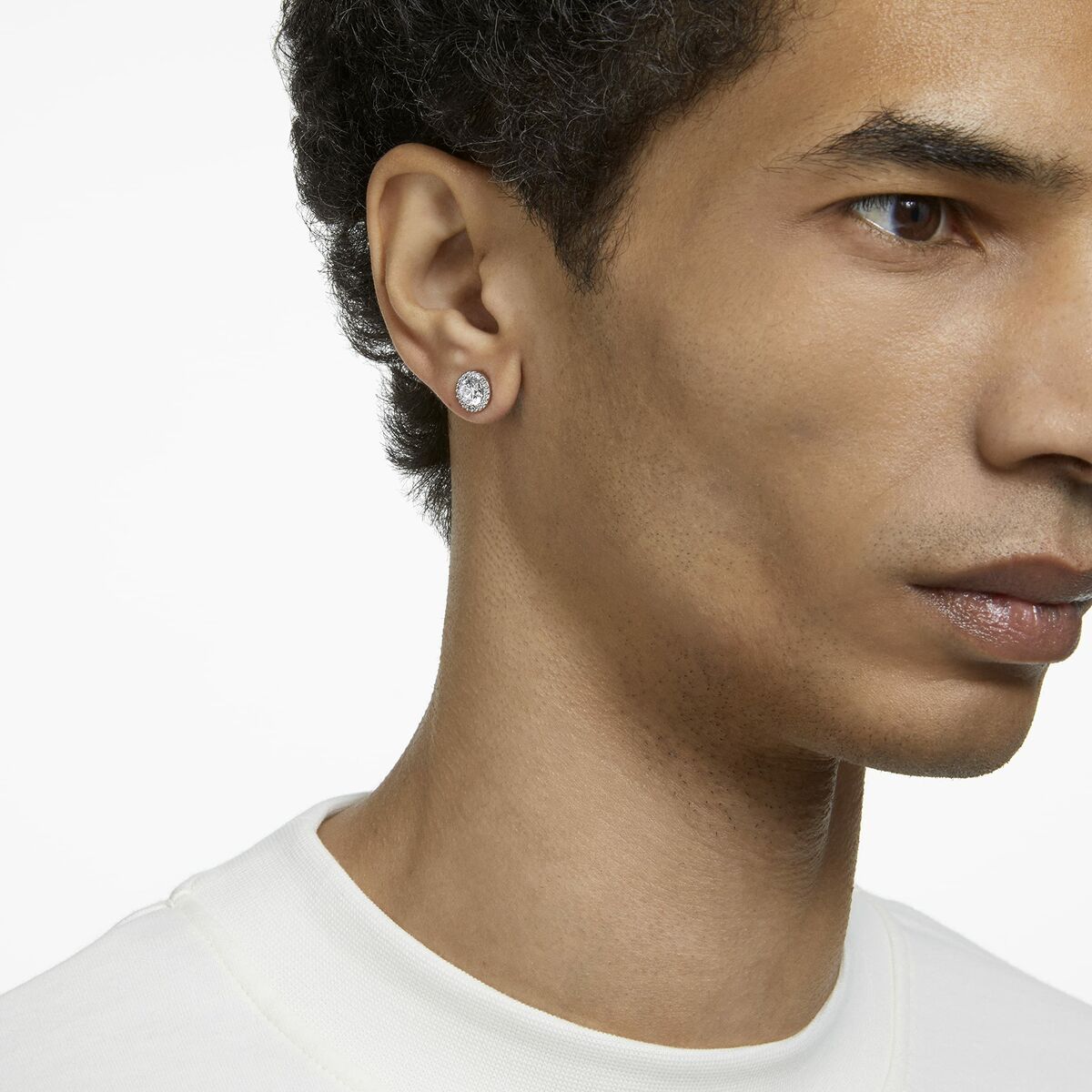 Detail van Swarovski oorbel met hoogwaardig kristal, gedragen aan het oor van een model.