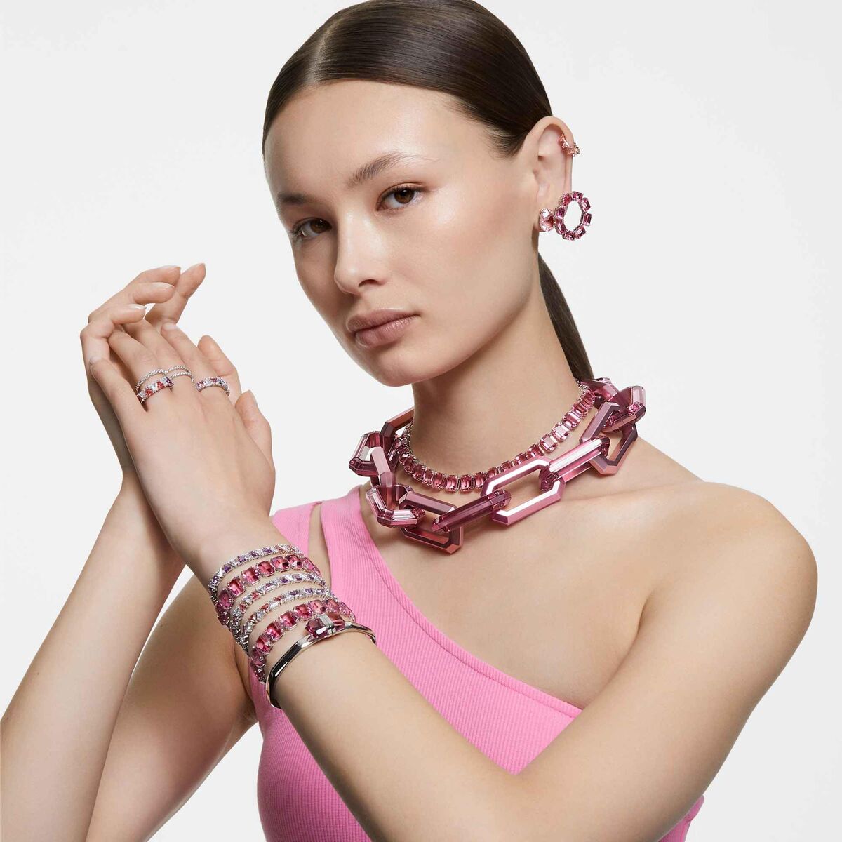 Zijaanzicht van een vrouw met Swarovski ringen en elegante sieraden in een stijlvolle outfit.