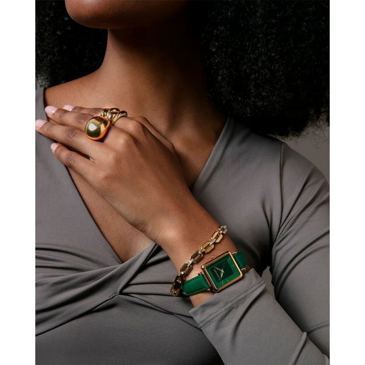 Detail van de Viceroy gouden ring, gedragen met een groene armband en stijlvolle outfit.