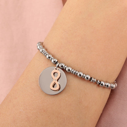 Detail van de La Petite Story armband met een ronde schijf en infinity-hanger in roestvrij staal.